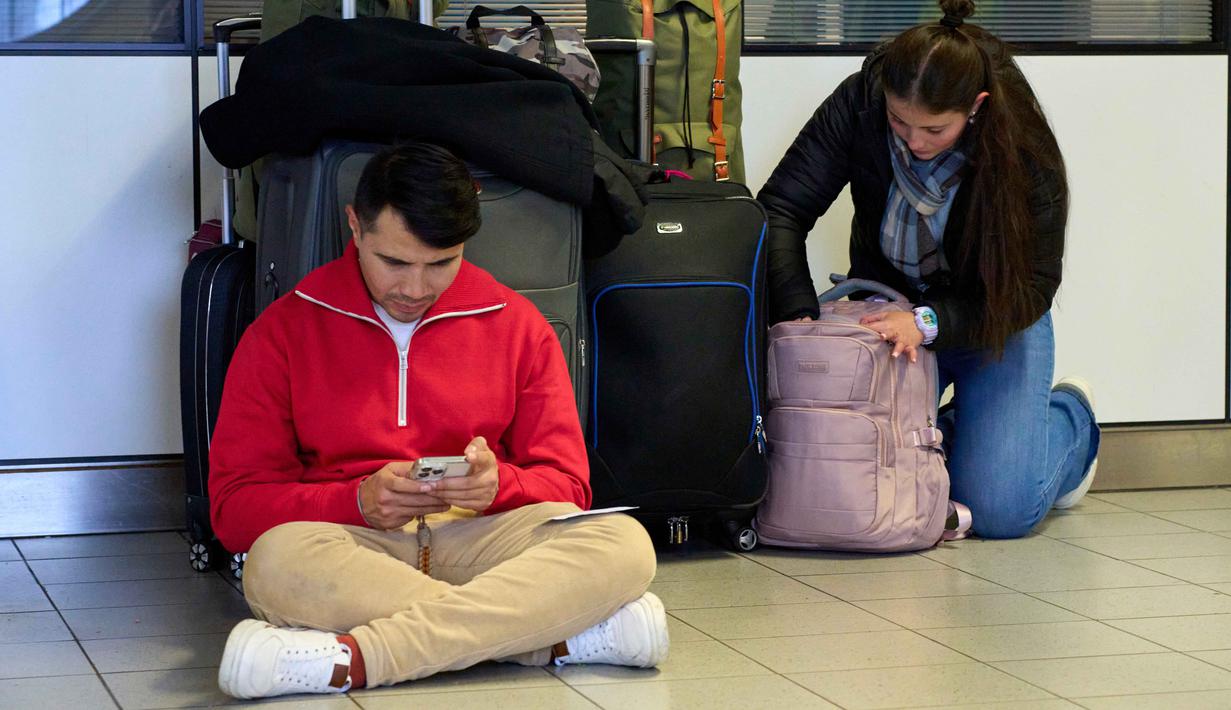 KLM juga telah meminta para penumpang yang penerbangannya dibatalkan agar tidak datang ke bandara demi mencegah kepadatan. Tampak dalam foto, para pelancong yang terlantar menunggu di bandara Schiphol di Amsterdam, Belanda, Rabu 7 Januari 2026. (AP Photo/Peter Dejong)