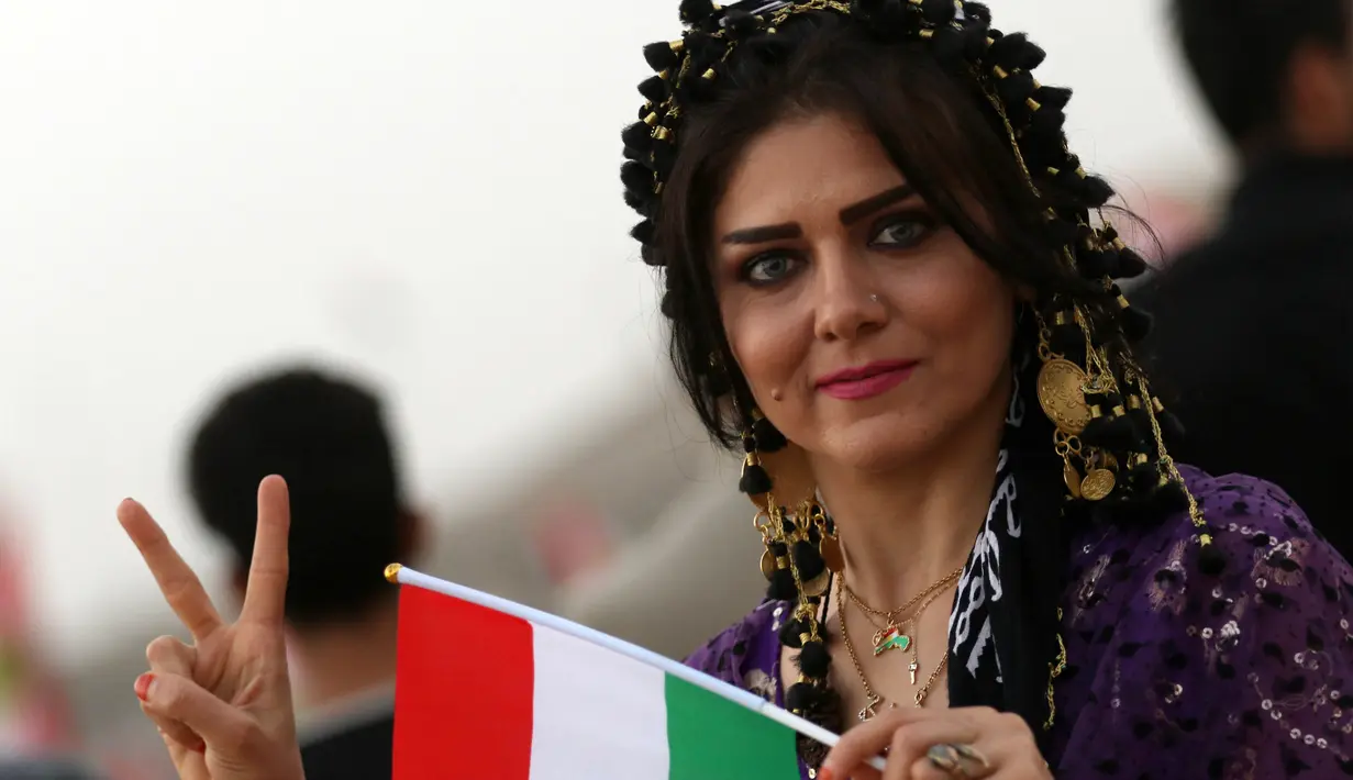Gadis Kurdi Iran berpose saat mengampanyekan referendum untuk kemerdekaan di kota Bahirka, Irak Utara (21/9). Referendum itunantinya akan menentukan apakah mereka akan tetap tergabung dalam negara Irak atau menjadi negara sendiri. (AFP Photo/Safin Hamed)
