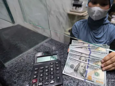 Karyawan menunjukkan uang pecahan dolar Amerika Serikat (AS) di salah satu gerai penukaran mata uang asing, Jakarta, Rabu (5/5/2026). Bank Indonesia (BI) resmi akan memperketat pembatasan pembelian dolar AS tanpa dokumen pendukung (underlying). (Kapanlagi.com/Budy Santoso)