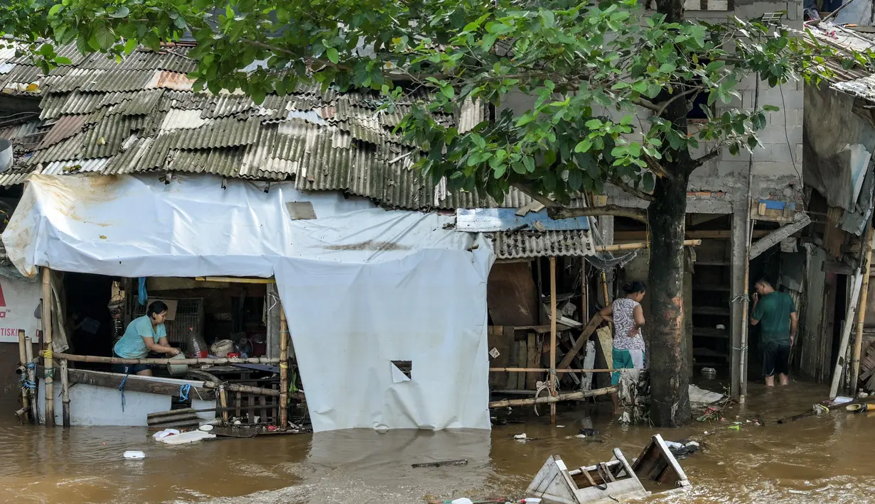 Tingginya intensitas hujan yang terjadi pada Minggu (6/7/2025) sore dan luapan air sungai terdekat menyebabkan banjir kembali melanda sejumlah wilayah Jakarta pada Senin pagi (7/7/2025). (BAY ISMOYO/AFP)