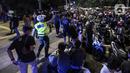 Polisi membubarkan kerumunan warga saat perayaan malam Tahun Baru di Jakarta, Jumat (31/12/2021). Polda Metro Jaya melakukan pengendalian mobilitas Crowd Free Night (malam bebas keramaian) dengan membubarkan warga yang nekat keluar rumah dan tidak mematuhi aturan. (Liputan6.com/Johan Tallo)