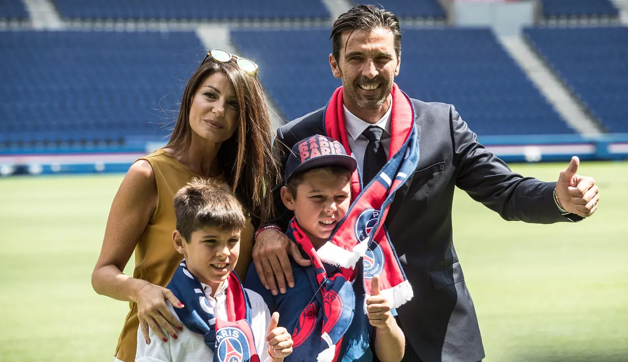 Kiper anyar PSG, Gianluigi Buffon berpose dengan kekasihnya, Ilaria d'Amico serta dua putranya, Louis-Thomas dan David-Lee saat resmi diperkenalkan sebagai pemain baru di stadion Parc des Princes, Paris, Senin (9/7). (AP/Jean-Francois Badias)