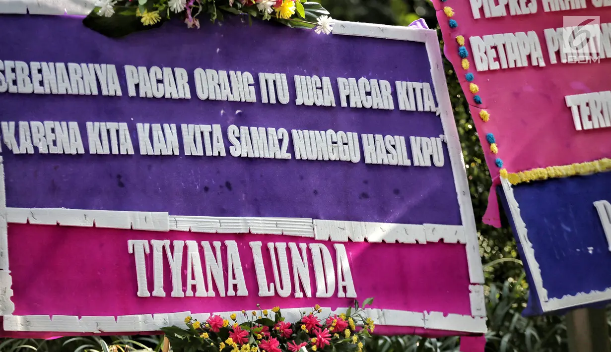Deretan karangan bunga kembali menghiasi depan Kantor Komisi Pemilihan Umum (KPU) Pusat dan dan ruas Jalan Imam Bonjol,  Menteng, Jakarta Pusat, Senin (6/5/2019). Karangan bunga yang berisi kata-kata unik dan lucu sudah berdatangan sejak subuh. (Liputan6.com/Faizal Fanani)
