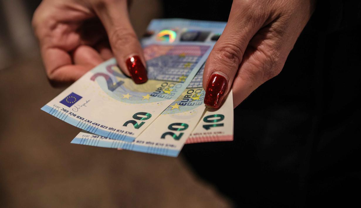 Seseorang menunjukkan uang kertas euro yang ditarik dari ATM di Sofia, Bulgaria, Kamis 1 Januari 2026, saat negara tersebut bergabung dengan serikat mata uang euro. Bulgaria resmi memasuki era baru kebijakan moneter dengan mengadopsi euro sebagai mata uang nasional. (AP Photo/Valentina Petrova)