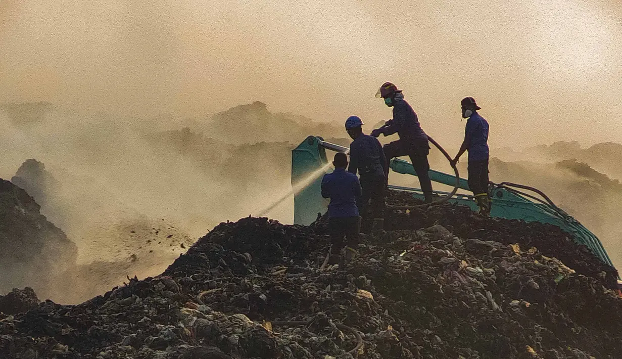 Petugas pemadam kebakaran berusaha memadamkan api di Tempat Pembuangan Akhir (TPA) Jatiwaringin, Kabupaten Tangerang, Banten, Jumat (03/07/2026). (Merdeka.com/ Arie Basuki)