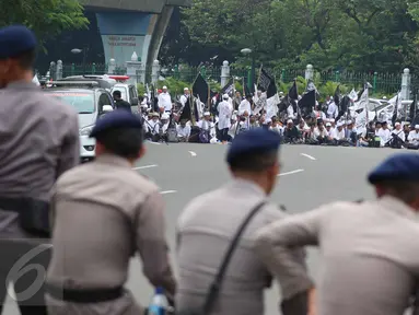 Massa aksi damai 4 November bersiap menggelar salat Jumat di Jalan Merdeka Barat, Jakarta, Jumat (4/11). Personel keamanan dari kepolisian pun disiagakan berbaris berhadapan dengan massa pendemo. (Liputan6.com/Faizal Fanani)