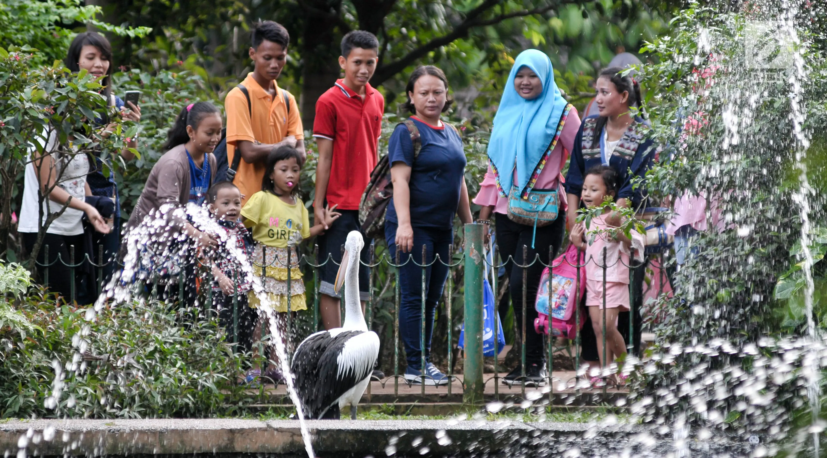Sejumlah warga melihat burung flamingo saat berwisata ke Taman Margasatwa Ragunan, Jakarta, Senin (26/6).  Jumlah pengunjung Ragunan pada hari ke-2 Lebaran ini diperkirakan mencapai 100 ribu orang. (Liputan6.com/Yoppy Renato)