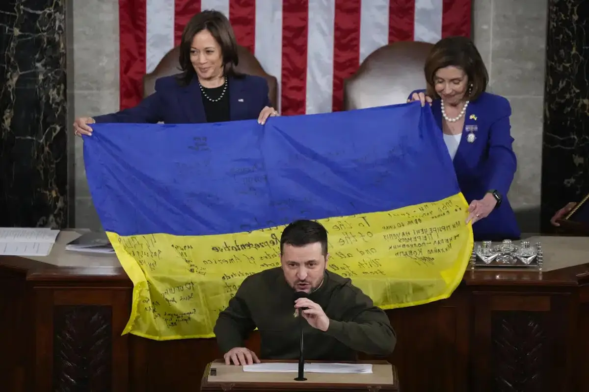 Presiden Ukraina Volodymyr Zelensky berpidato di pertemuan gabungan Kongres di Capitol Hill di Washington, Rabu, 21 Desember 2022. Ia menyerahkan bendera Ukraina yang ditandatangani oleh pasukan garis depan di Bakhmut. (AP Photo/Jacquelyn Martin)