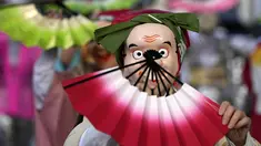 Seniman yang mengenakan topeng badut tradisional Jepang tampil selama Festival Konpira di kuil Kotohiragu di distrik bisnis Toranomon, Tokyo, Selasa (10/1/2023). Festival Konpira pertama di tahun 2023 ini dimeriahkan dengan penampilan para seniman yang mengenakan topeng tradisional Jepang. (AP Photo/Eugene Hoshiko)