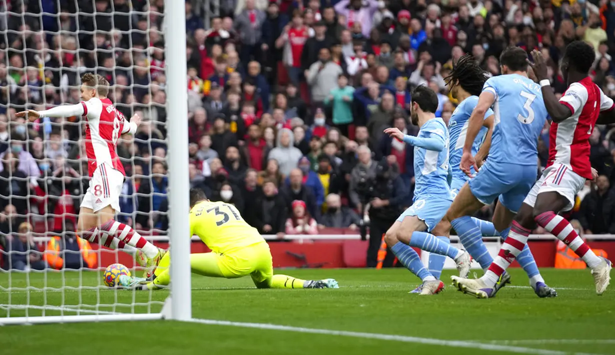 Penjaga gawang Manchester City Ederson (tengah) berebut bola dengan pemain Arsenal Martin Odegaard (kiri) pada pertandingan sepak bola Liga Inggris di Stadion Emirates, London, Inggris, 1 Januari 2022. Manchester City menang 2-1. (AP Photo/Matt Dunham)