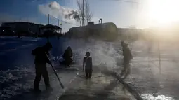Seorang anggota klub renang es bersiap untuk berenang ke dalam air sedingin es saat suhu turun hingga minus 34 derajat celsius, di Novosibirsk, Rusia, Sabtu (26/12/2020). Saat musim dingin datang, warga di Rusia justru mendatangi air yang dingin untuk berenang. (Rostislav NETISOV/AFP)