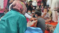 Anak jalanan dan pengamen yang berusia 6-11 Tahun di Kota Bogor disuntik vaksinasi covid-19. (Liputan6.com/Achmad Sudarno)