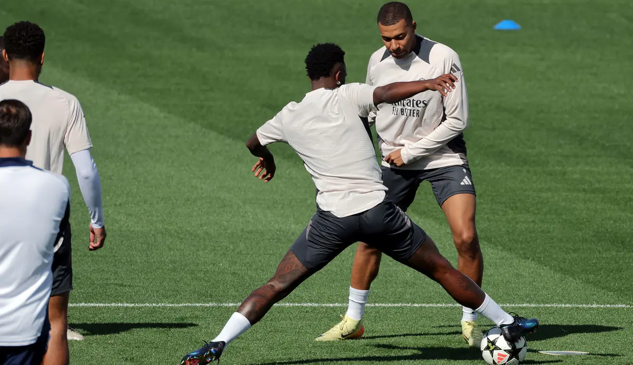 Pemain Real Madrid, Kylian Mbappe (kanan) berebut bola dengan rekannya, Vinicius Jr saat berlatih menjelang laga melawan VfB Stuttgart saat Liga Champions 2024/2025 di fasilitas pelatihan Valdebebas, Madrid, Spanyol, 16 September 2024. (AFP/Thomas Coex)