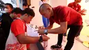 Pemain Persija Jakarta, Riko Simanjuntak (kanan) memberikan tanda tangan kepada seorang penggemar pada acara meet and greet bertajuk Rumah Indofood di Jakarta International Expo (JIExpo) Kemayoran, Jakarta Pusat, pada Kamis (22/6/2023). (Bola.com/M Iqbal Ichsan)