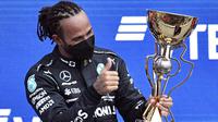Pembalap Mercedes, Lewis Hamilton, mengunci kemenangan pada balapan F1 GP Rusia di Sirkuit Sochi, Minggu (26/9/2021). Kemenangan itu mengantar Hamilton mengukir sejarah baru. (AFP/Alexander Nemenov)