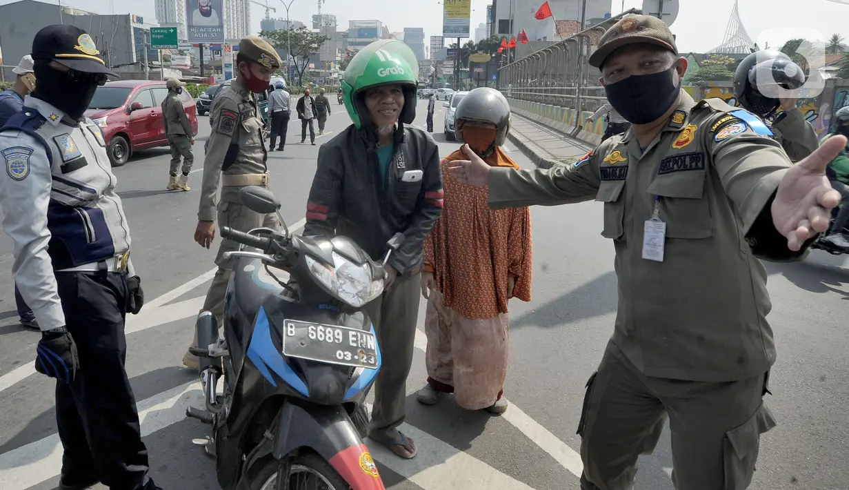 Petugas memberhentikan pengendara sepeda motor yang tidak mengenakan masker di kawasan Jalan Ir. H. Juanda, Depok, Jawa Barat, Kamis (23/7/2020). Razia tersebut dilakukan oleh tim gabungan dari Polresta Depok dan Satpol PP. (merdeka.com/Arie Basuki)