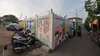 Aktivitas warga di dekat mural Betawi yang berada di Kampung Pitung, Marunda, Jakarta, Senin (2/7). Mural-mural bernuansa Betawi kini menghiasi destinasi wisata rumah dan masjid Pitung. (Merdeka.com/Iqbal S. Nugroho)