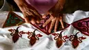 Seorang pekerja membuat desain batik di sebuah bengkel di Banda Aceh, Aceh, Rabu (13/10/2021). Batik Aceh memiliki ciri khas tersendiri, yaitu menggunakan perpaduan unsur alam dan budaya dari masyarakat Aceh sendiri. (Chaideer MAHYUDDIN/AFP)