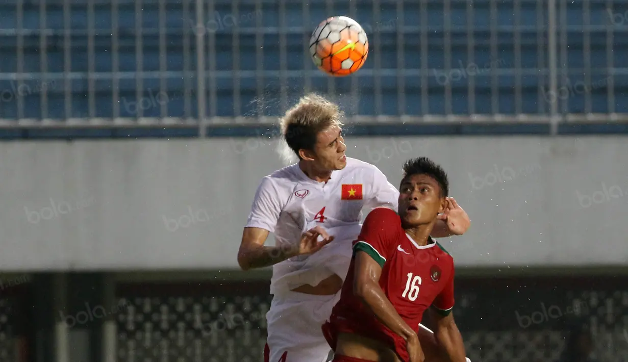 Aksi Fachrudin (kanan) menghadang pemain Vietnam pada laga uji coba di Stadion Maguwoharjo, Minggu (09/10/2016). (Bola.com/Nicklas Hanoatubun)