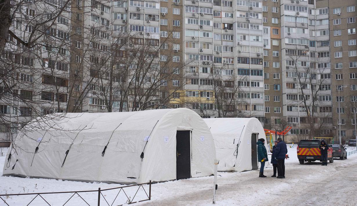 Pemerintah setempat mengakui upaya pemulihan berjalan bertahap dan membutuhkan waktu. Tampak dalam foto, warga setempat mengobrol sambil berdiri di dekat tenda darurat tempat orang-orang dapat menghangatkan diri setelah serangan udara rutin Rusia terhadap fasilitas energi negara itu di tengah musim dingin, Kyiv, Ukraina, Selasa 13 Januari 2026. (AP Photo/Efrem Lukatsky)