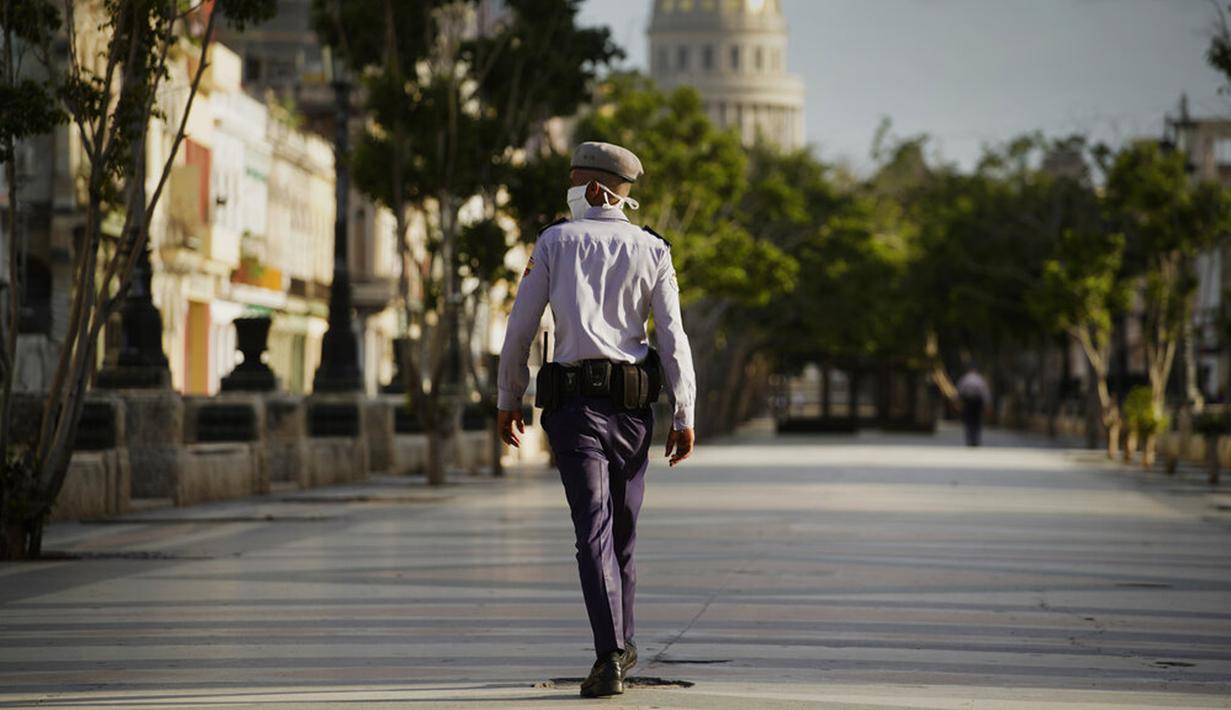 Polisi mengenakan masker saat berpatroli dekat Capitol selama penerapan jam malam di Havana, Kuba, Selasa (1/9/2020). Otoritas Kuba menerapkan lockdown selama 15 hari di Havana untuk keluar dari penularan COVID-19 tingkat rendah tetapi terus-menerus. (AP Photo/Ramon Espinosa)