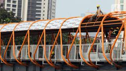 Pekerja menyelesaikan pembangunan jembatan penyeberangan orang (skywalk) di kawasan Kebayoran Lama, Jakarta, Rabu (2/11/2022). Pengerjaan skywalk sepanjang 500 meter dengan desain cahaya artistik dan dilengkapi fasilitas lift nantinya mengintegrasikan Stasiun Kebayoran dengan Halte Transjakarta Koridor 8 dan Koridor 13. (Liputan6.com/Herman Zakharia)