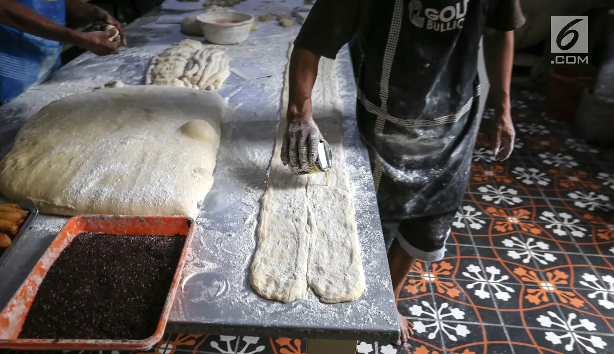 Karyawan membuat bahan adonan roti di Toko Roti GO, Purwokerto, Jawa Tengah, Senin (22/4). Toko roti yang berdiri sejak tahun 1898 tersebut diproduksi dengan fermentasi (bibit roti) dan tanpa bahan campuran atau pengawet. (Liputan6.com/Fery Pradolo)