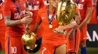 Penyerang Timnas Cile, Alexis Sanchez (kanan) mencium trofi juara Copa America Centenario 2016, Senin (27/6/2016) pagi WIB. Sanchez terpilih sebagai Pemain Terbaik Copa America Centenario.  (Reuters/Brad Penner)