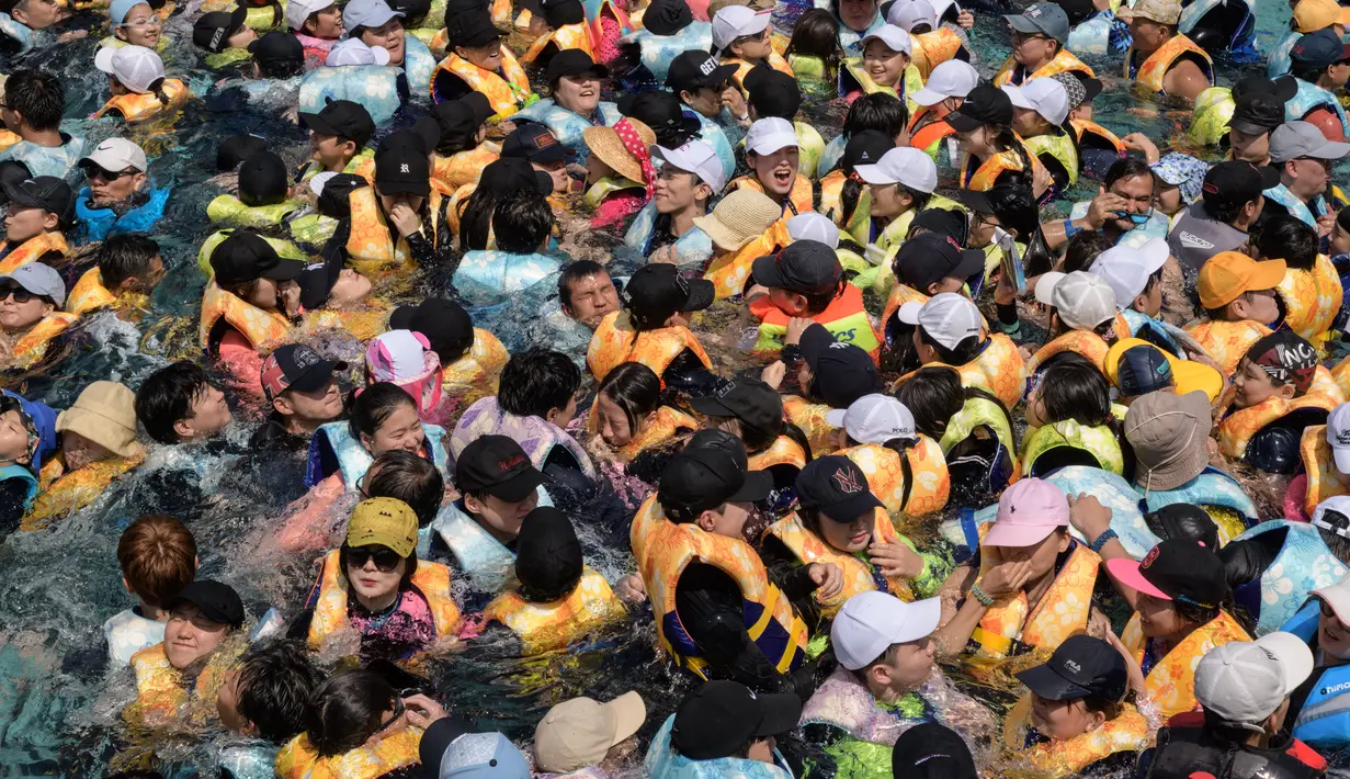 Wisatawan memadati water park Caribbean Bay di Yongin, luar Seoul, Senin (6/8). Cuaca ekstrem dengan suhu mencapai hampir 40 derajat celcius membuat ratusan warga Korea Selatan memenuhi kolam renang untuk mengurangi hawa panas. (Ed JONES/AFP)