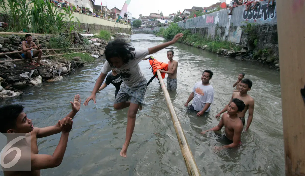 Salah satu peserta lomba gagal melintasi jembatan bambu satu di Yogyakarta, Selasa (9/8). Lomba diselenggarakan untuk menyambut HUT RI ke-71. (Liputan6.com/Boy Harjanto)
