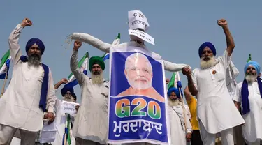 Sejumlah petani membentangkan poster bergambar Perdana Menteri India Narendra Modi dengan logo KTT G20 India selama protes di Amritsar pada tanggal 8 September 2023. (Narinder NANU/AFP)