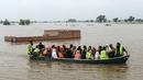 Relawan mengevakuasi warga desa yang terdampak banjir dengan perahu di Jalalpur Pirwala, distrik Multan, provinsi Punjab, pada 8 September 2025. (Shahid Saeed MIRZA/AFP)