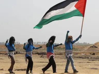 Warga Palestina bergaya seperti karakter dari film "Avatar" mengibarkan bendera selama protes menuntut hak untuk kembali ke kampung halaman mereka di perbatasan Israel-Gaza, Timur Khan Yunis di Gaza selatan Strip, (4/5). (AFP Photo/Said Khatib)