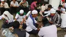 Massa aksi damai berkumpul makan di pinggir Jalan Medan Merdeka Timur, Jakarta, Jumat (4/11). Massa melakukan aksi di depan Istana Negara menuntut penegakan hukum kasus dugaan penistaan agama. (Liputan6.com/Faizal Fanani)