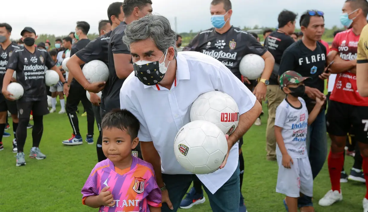 Coach Teco juga menyempatkan diri berfoto bersama salah satu pesepak bola cilik yang hadir di Training Ground Bali United. (Bola.com/ M Iqbal Ichsan)