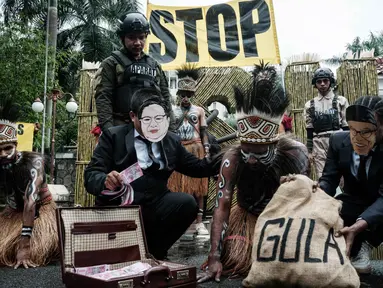 Aktivis Greenpeace Indonesia bersama beberapa pemuda Papua menggelar aksi teatrikal saat berunjuk rasa di depan Kantor Kementerian Koordinator bidang Perekonomian, Jakarta, Kamis (18/12/2025). Aktivis Greenpeace Indonesia bersama beberapa pemuda Papua menggelar aksi damai di depan Kantor Kementerian Koordinator bidang Perekonomian, Jakarta. (Yasuyoshi Chiba/AFP)