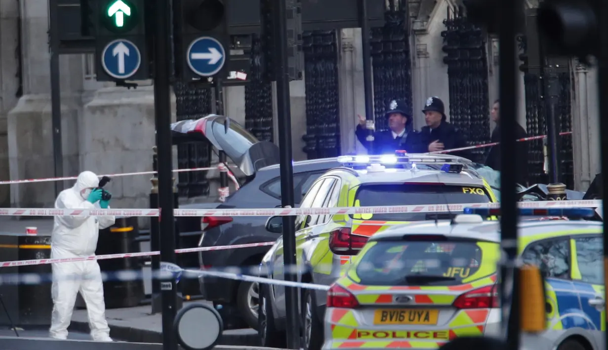 Petugas forensik meneliti lokasi serangan teror Inggris di dekat gedung parlemen di London, Rabu (22/3). Sedikitnya lima orang tewas dalam serangan teror di Jembatan Westminster dan di dekat Gedung Parlemen itu. (Yui Mok/PA via AP)