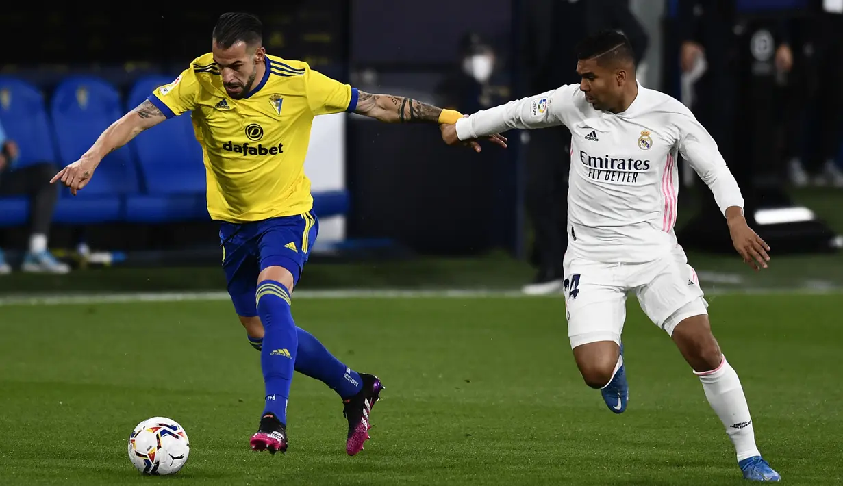 Pemain Cadiz Alvaro Negredo (kiri) berebut bola dengan pemain Real Madrid Casemiro pada pertandingan La Liga Spanyol di Stadion Ramon Carranza, Cadiz, Spanyol, Rabu (21/4/2021). Real Madrid menang 3-0. (AP Photo/Jose Breton)