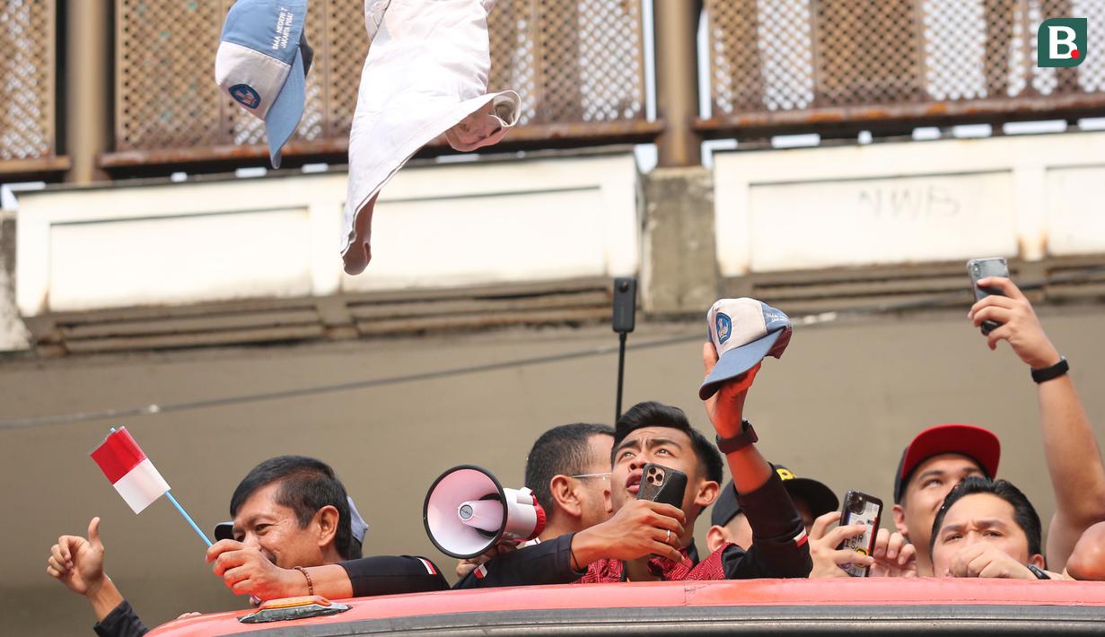 Pemain Timnas Indonesia U-22, Pratama Arhan saat tertimpuk seragam dari salah satu pelajar SMA Negeri 7 Jakarta Pusat saat pawai pawai bertajuk Kira87uara Kontingen SEA Games 2023 yang berlangsung dari Kemenpora hingga Stadion Utama Gelora Bung Karno (SUGBK), Senayan, Jakarta, Jumat (19/5/2023). Acara tersebut merupakan bentuk perayaan keberhasil kontingen Indonesia yang telah melampaui target medali emas di SEA Games 2023 dan kesuksesan Timnas Indonesia U-22 yang telah mengakhiri puasa gelar 32 tahun di SEA Games 2023. (Bola.com/Bagaskara Lazuardi)