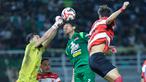 Kiper Madura United, Diky Indriyana, berusaha menghalau bola saat melawan Persebaya Surabaya pada laga BRI Super League di Stadion Gelora Bung Tomo, Surabaya, Jumat (17/04/2026). (Bola.com/M Iqbal Ichsan)