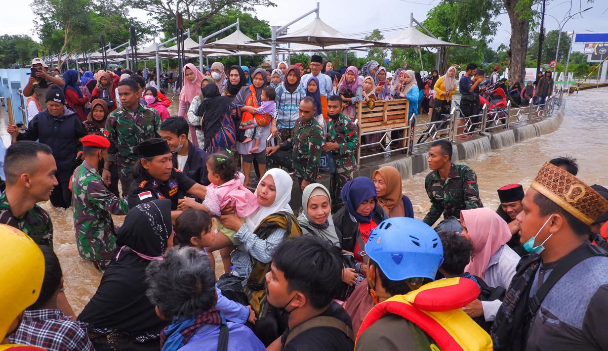 Anggota tim SAR membantu warga mengungsi pasca banjir di Serang, Provinsi Banten (1/3/2022).  Berdasarkan data sementara dari Polres Serang Kota, ada 20 titik banjir yang merendam pemukiman warga di Kota Serang. (AFP/Dziki Oktomauliyadi)