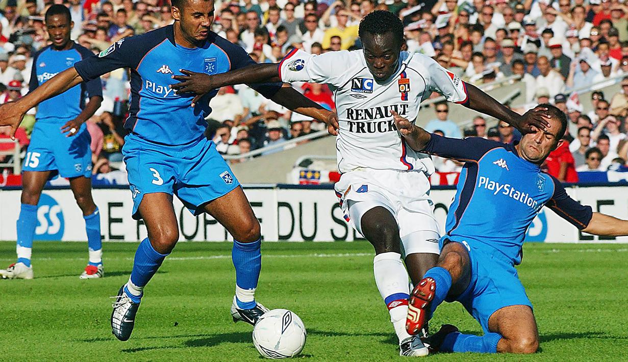 Gelandang Lyon, Michael Essien, berusaha melewati hadangan bek Auxerre, Jean-Sebastien Jaures. Karier Essien mulai berkembang saat dirinya hijrah dari Bastia ke Lyon pada tahun 2003 lalu. (AFP/Pascal George)