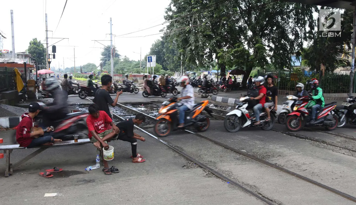 Pengendara motor melintas di perlintasan kereta api yang tidak berpalang pintu di kawasan Roxy, Jakarta, Rabu (21/3). Akhirnya antara warga dan petugas menyepakati untuk membuka celah selebar dua meter di lokasi tersebut. (Liputan6.com/Arya Manggala)