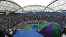 Lapangan Arthur Ashe sempat diguyur hujan sebelum partai final tunggal putra AS Terbuka 2015 digelar. Senin (14/8/2015) pagi WIB. (AFP Phot/Timothy A. Clary)