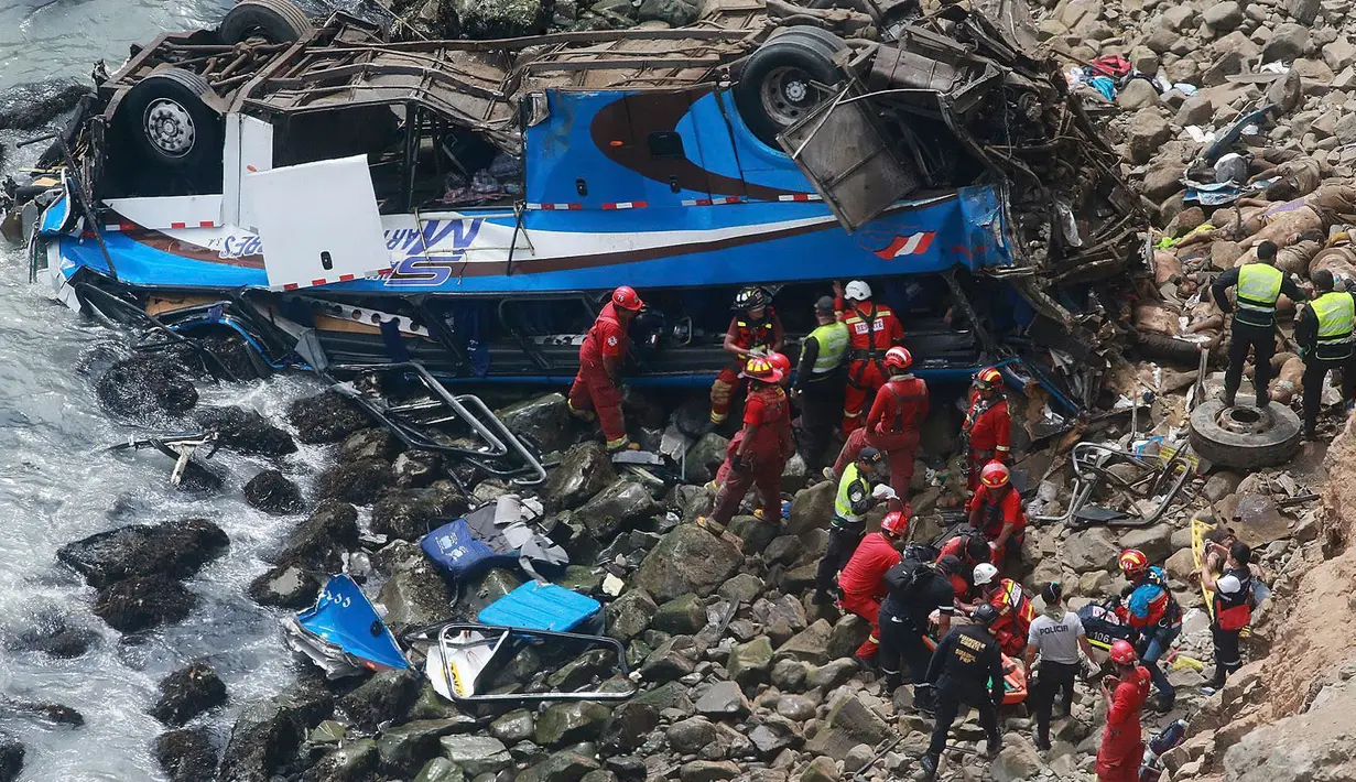 Petugas pemadam kebakaran mengevakuasi tubuh korban dari sebuah bus yang jatuh dari tebing setelah ditabrak oleh truk trailer, di Pasamayo, Peru, Selasa (3/1). Sedikitnya 35 orang tewas dalam insiden tersebut. (Vidal Tarky, Andina News Agency via AP)