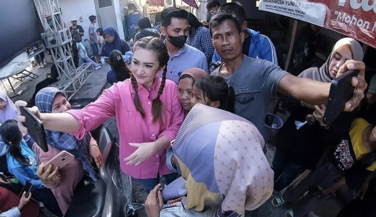 Dengan rambut yang dikepang dua, Nafa yang mengenakan kemeja pink dipadukan celana denim mengajak warga untuk selfie. Credit (@nafaurbach)