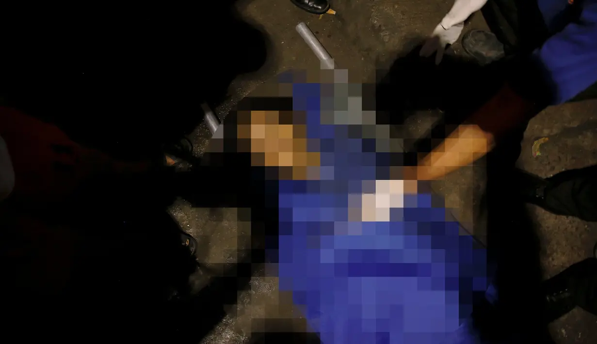 Petugas membawa salah satu korban yang tewas dalam penembakan oleh orang tak dikenal di Manila, Filipina (1/11). Menurut keterangan polisi dan saksi mata, terdapat lima orang yang tewas ditembak oleh orang tak dikenal. (REUTERS/Damir Sagolj)