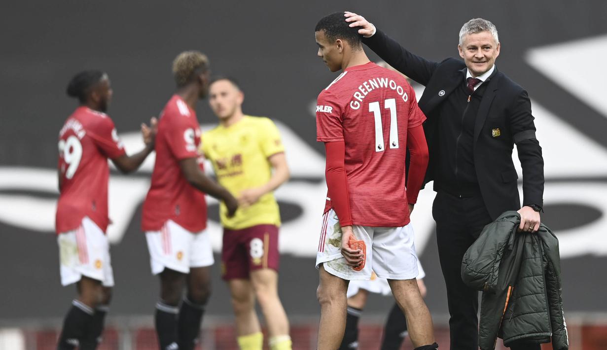 Pelatih Manchester United, Ole Gunnar Solskjaer, mengusap kepala Mason Greenwood usai laga melawan Burnley pada laga Liga Inggris di Stadion Old Trafford, Minggu (18/4/2021). MU menang 3-1 Burnley. (Gareth Copley/Pool via AP)