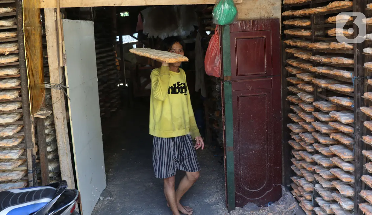 Pekerja membawa oncom di industri rumahan untuk di jual di wilayah Jakarta, Selasa (19/11/2019). Oncom yang di jual seharga Rp 2000 untuk memenuhi kebutuhan di pasar pasar tradisional di kawasan tersebut. (Liputan6.com/Angga Yuniar)