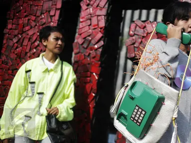Sebuah tas yang dirancang dari limbah telepon dipamerkan oleh aktivis yang tergabung dalam Greenpeace Indonesia saat menggelar aksinya di car free day dikawasan Bunderan HI, Jakarta, Minggu (26/2). (Liputan6.com/Faizal Fanani)